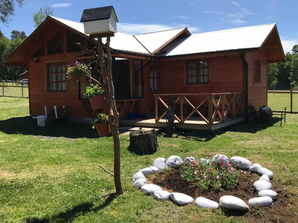 Una de las cabañas con su jardín